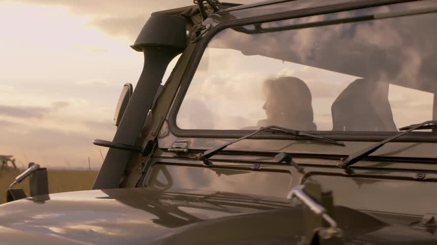 Someone is watching the sun setting from their jeep