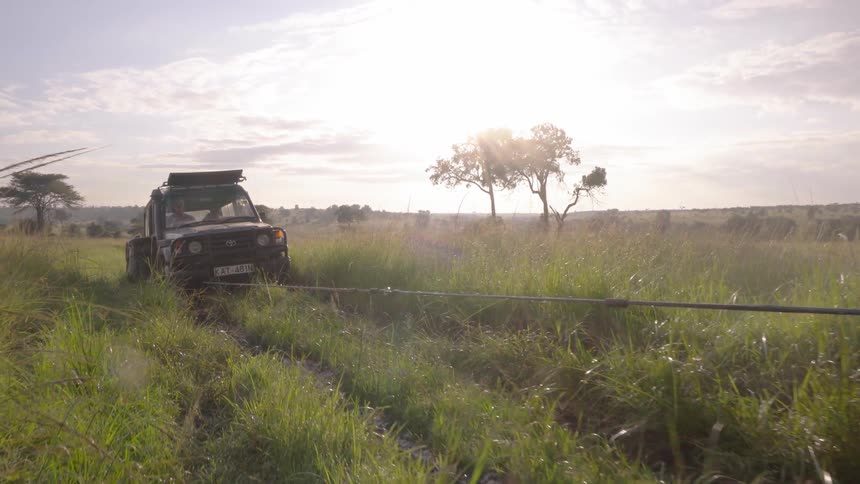 A jeep is stuck in the mud and another is helping pull it out