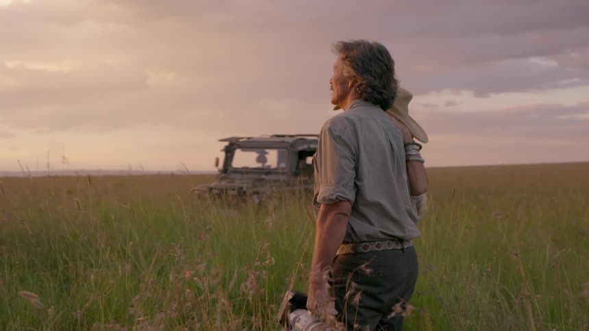 Two people are standing shoulder to shoulder and watching the sunset