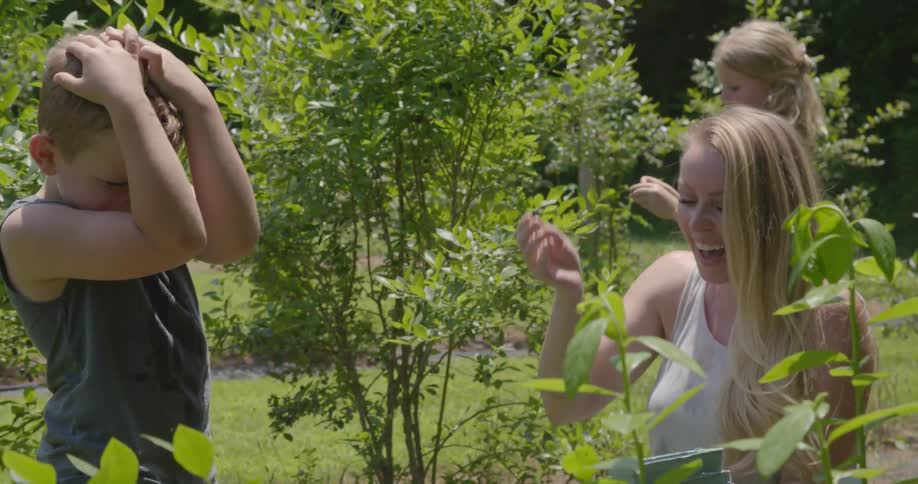 A woman and her children are working in a garden together