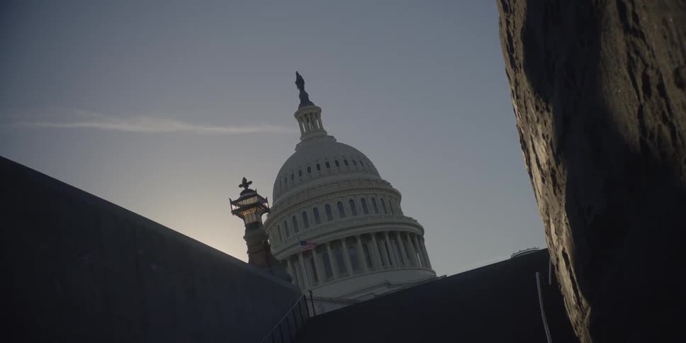 A large building has a dome at the top on a clear day