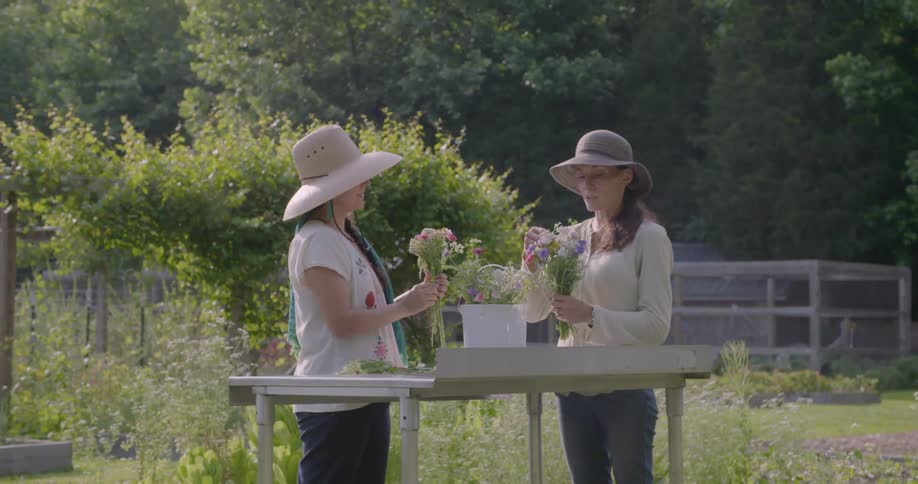 Two women arranging flowers and talking