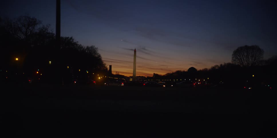 Cars driving down a road at sunset