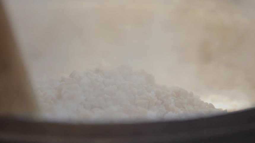 Food is stirred in a pot with a wooden spoon