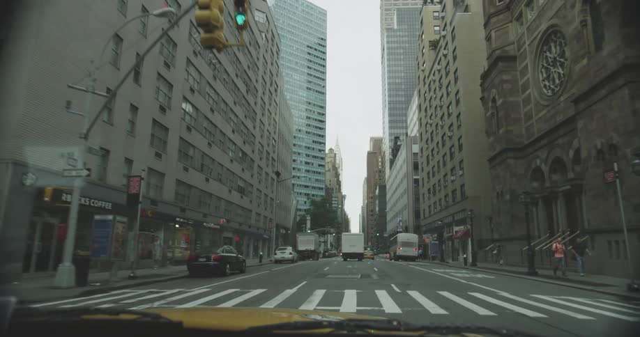 A car rolls down a street in a city