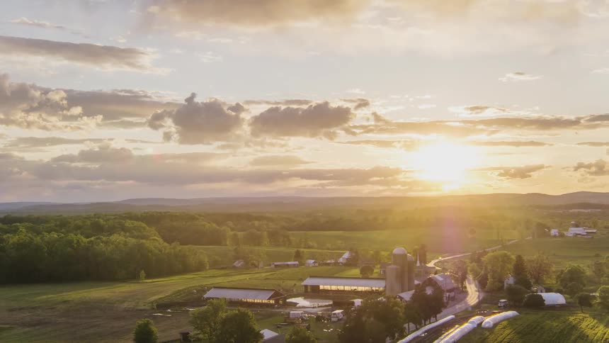 The sun is slowly setting over the large farm