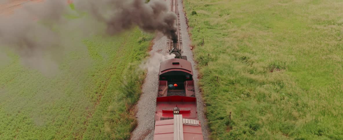 The red train is moving fast down the tracks