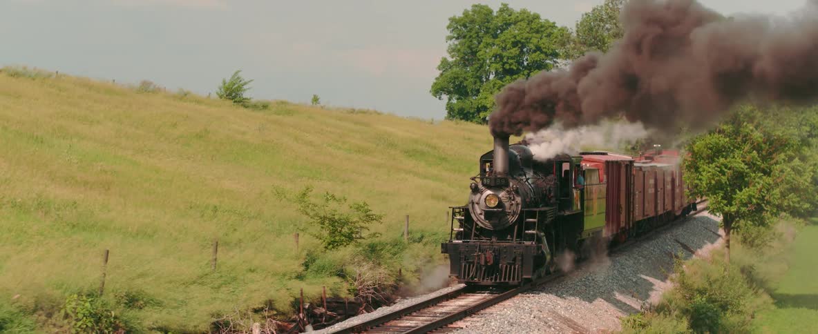 The train is traveling slowly giving off billows of smoke