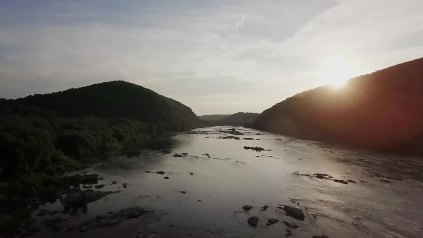 The sun sets over a mountain river