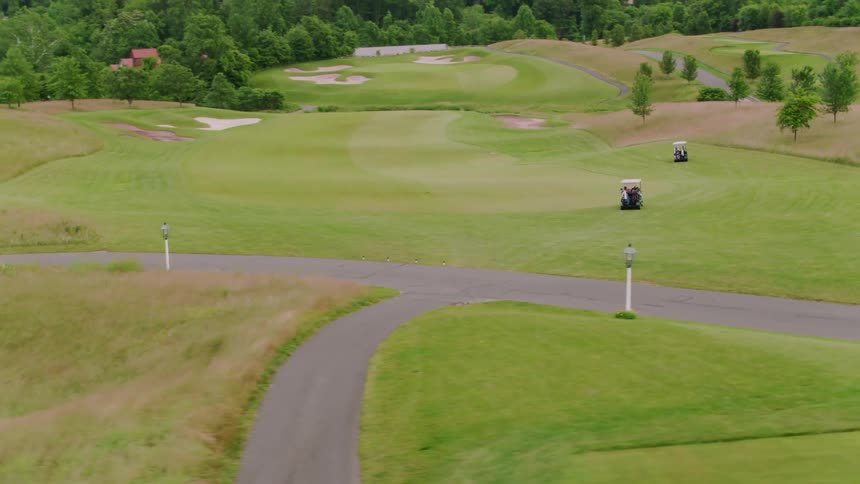 Golfers ride in golf carts on a course