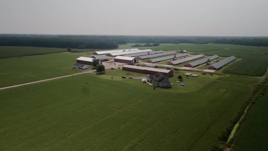 The farm has many large buildings and a house on the side