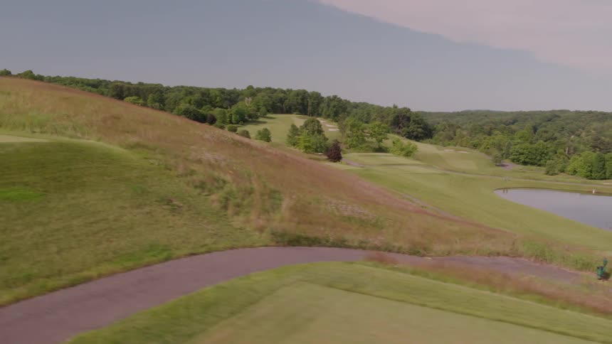 A helicopter is landed up on the top of a green golf course hill