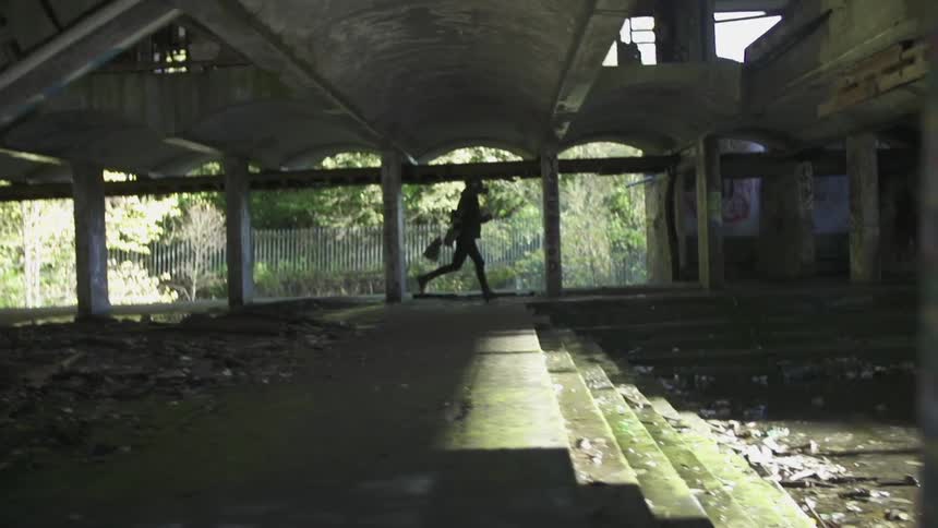 A person runs through a concrete structure