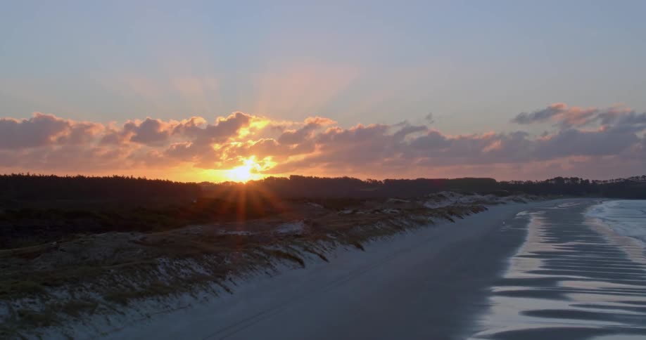 The sun is sitting on a quiet beach