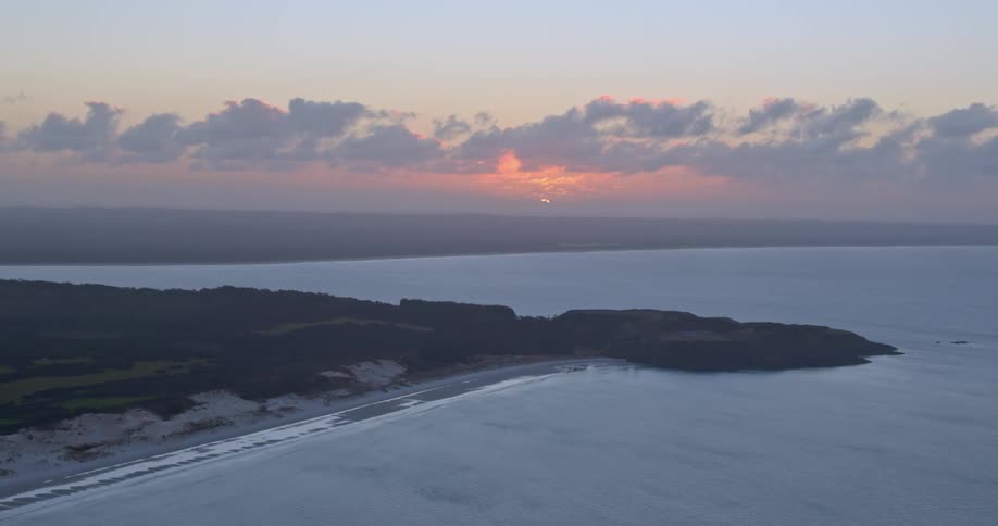 The sun sets over a body of water