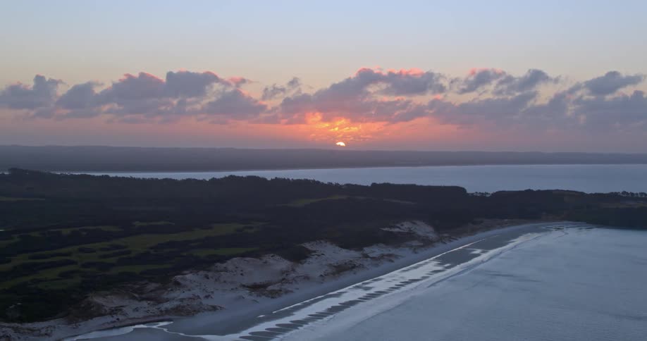 The sun is setting on the beaches shore