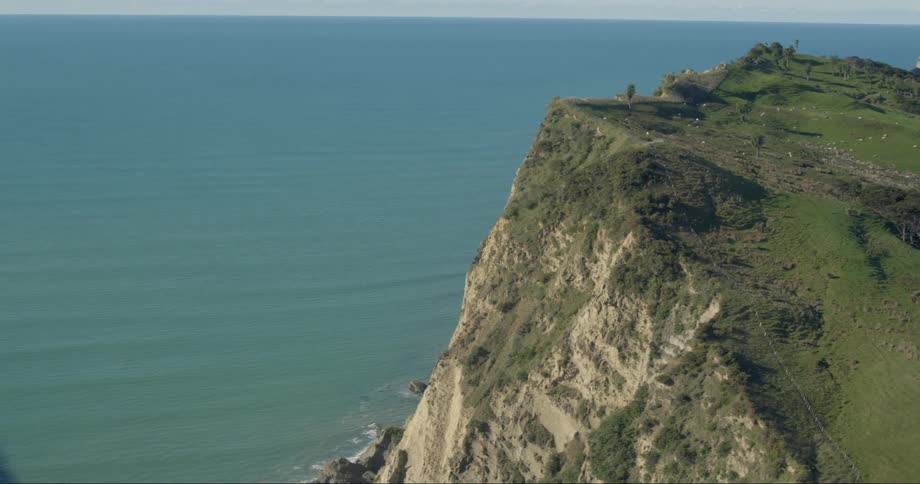 A cliff side is facing the ocean