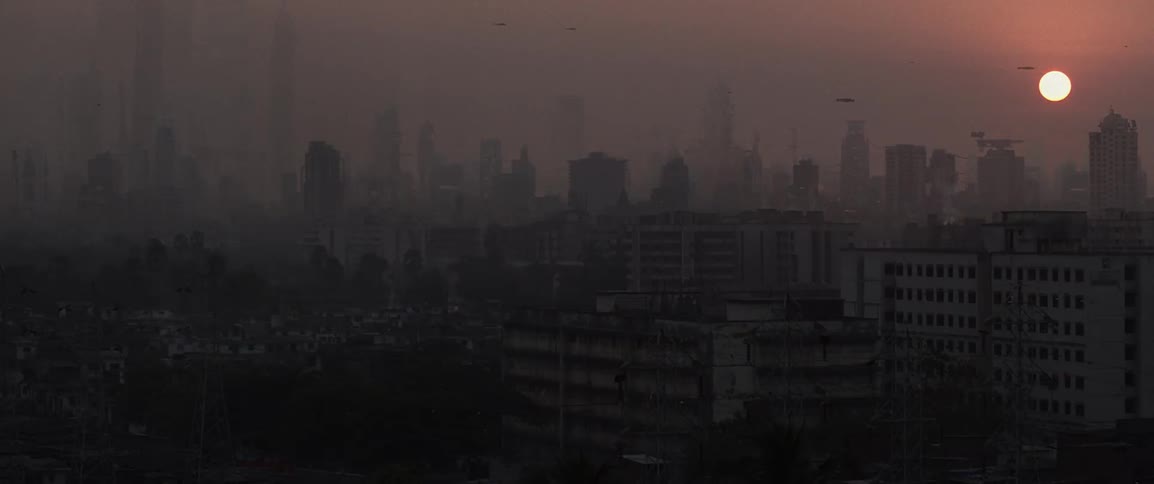 A smoggy future city at sunset with spaceships