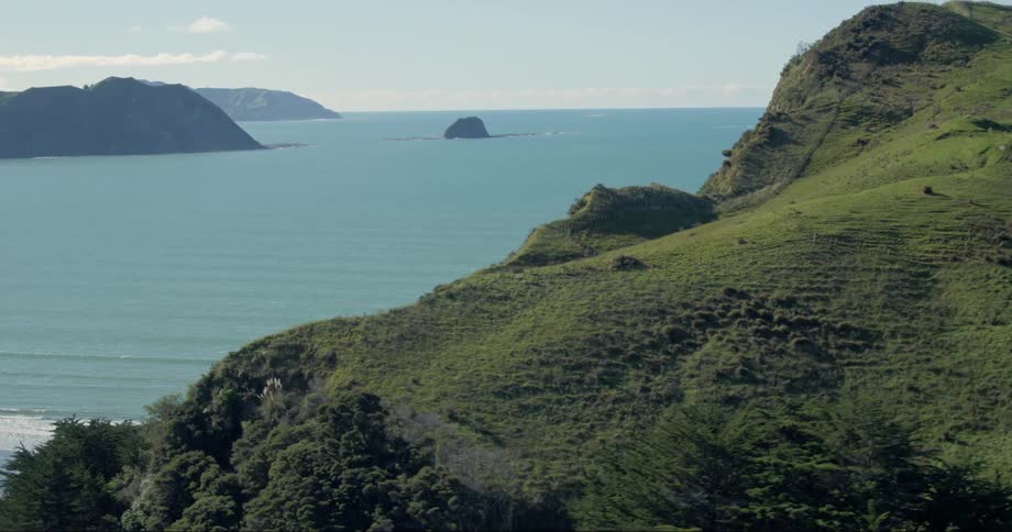 The blu water is crashing against the green cliffs