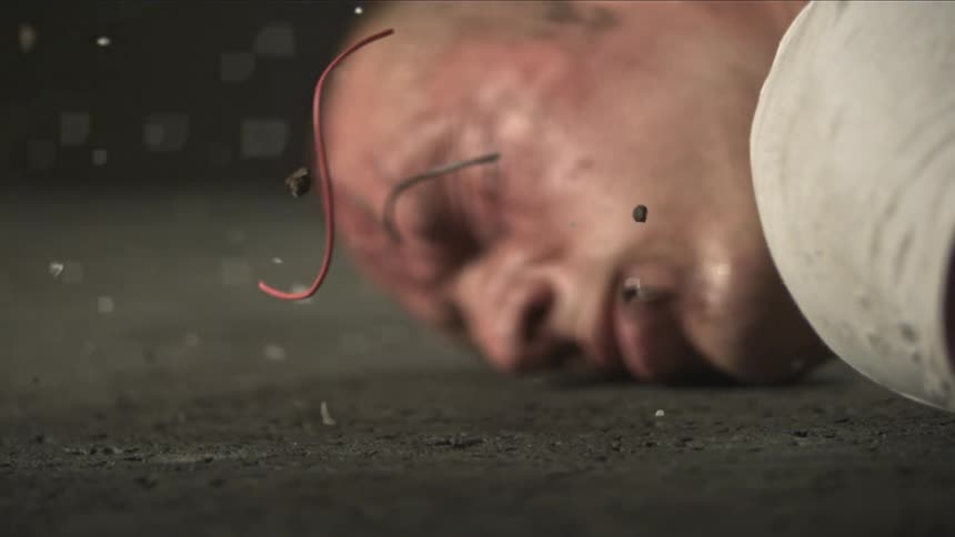 A man smacks his head on the ground while getting hit with debris