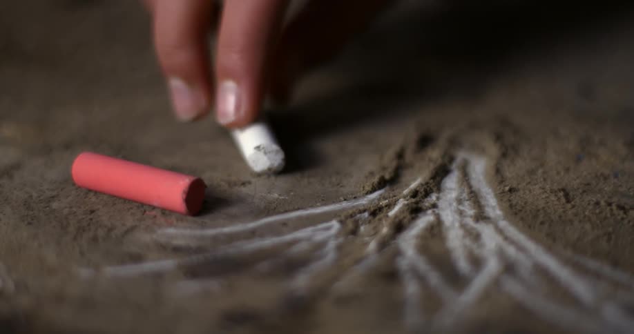 Person drawing on the ground with chalk