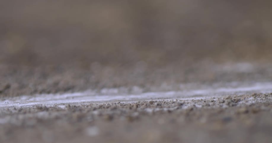 A person is drawing with chalk on the ground