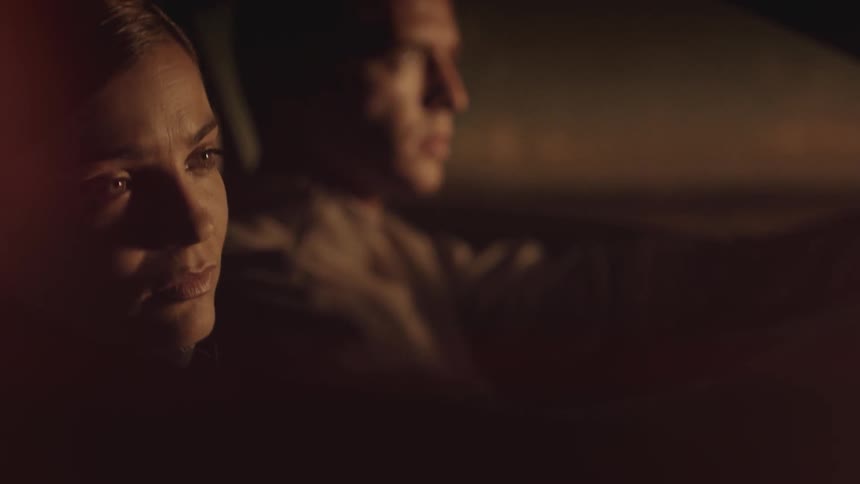 A man and woman travel in a car at night