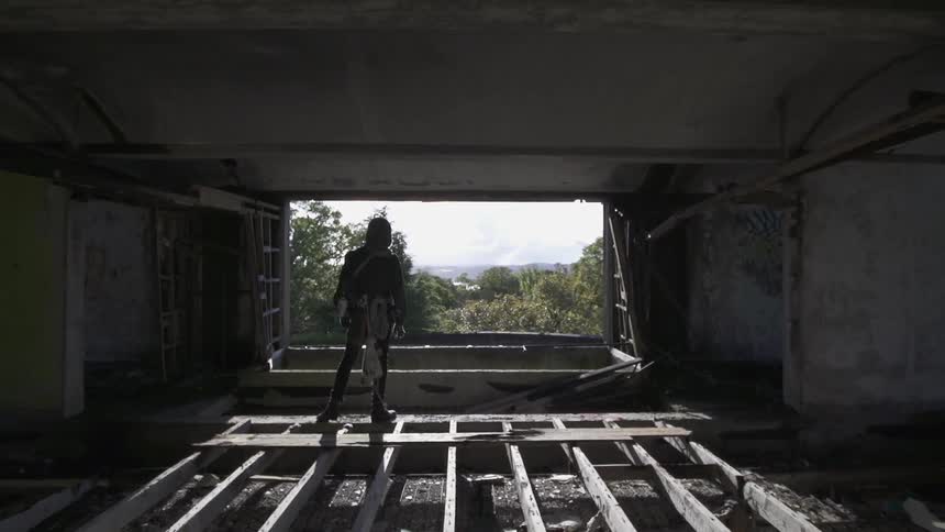 A woman is walking over a plank under a bridge