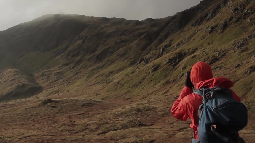 A woman is hiking alone in the mountains