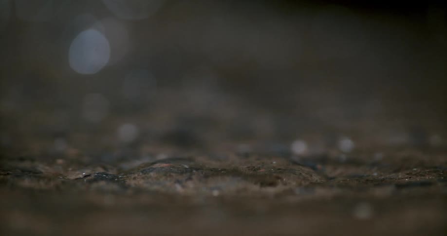 A water drop splashes in a puddle in slow motion