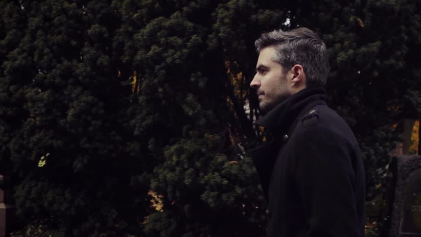 A man is walking through a cemetery