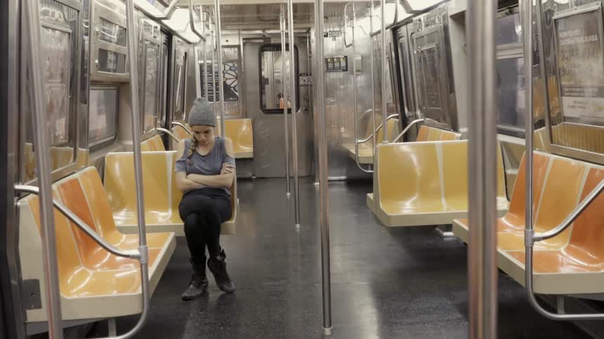 Woman rides alone on a subway train