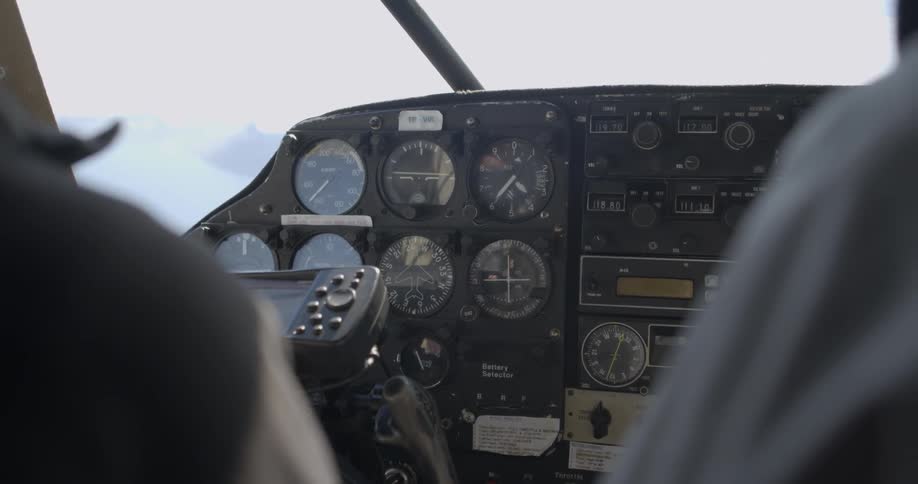 A pilot is flying a plane during the day