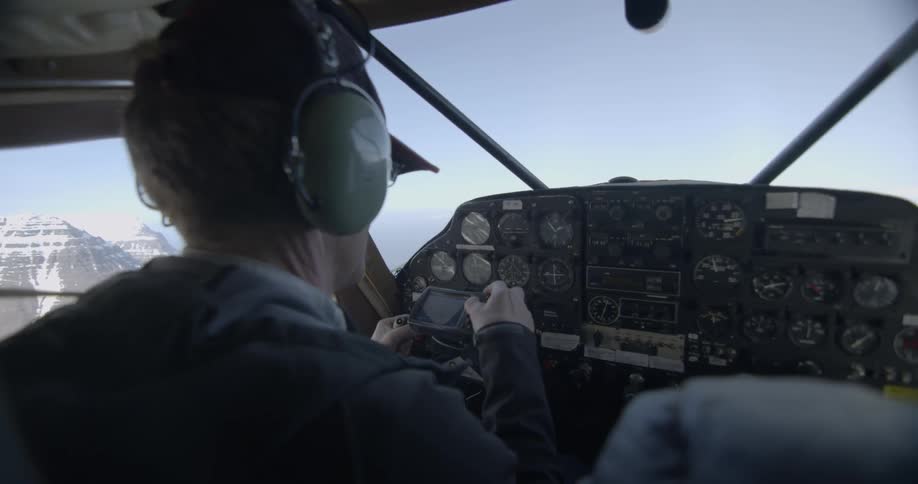 A pilot is flying a plane and looking at his instruments