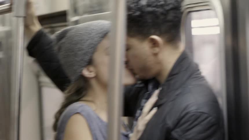 Man and woman make out on subway train