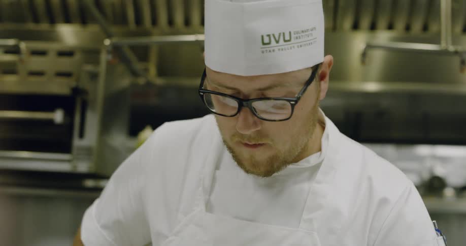 A man is preparing food in a restaurant kitchen
