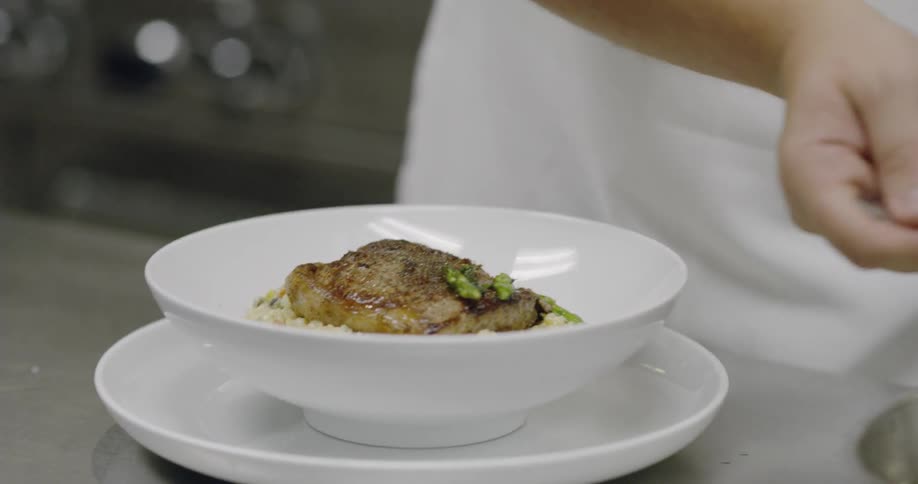 A chef plates a dish in a restaurant