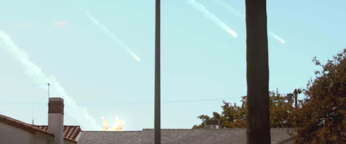 Meteors fall from the sky and strike buildings on a sunny day