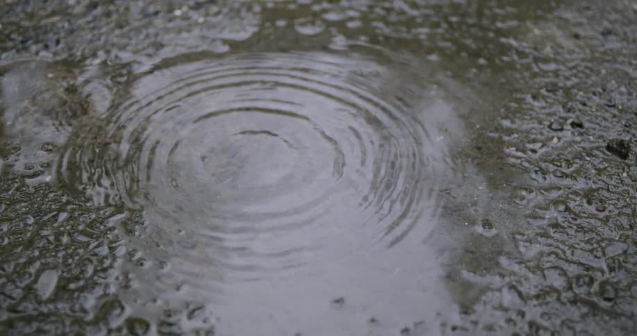 Water drips into a puddle causing a splash