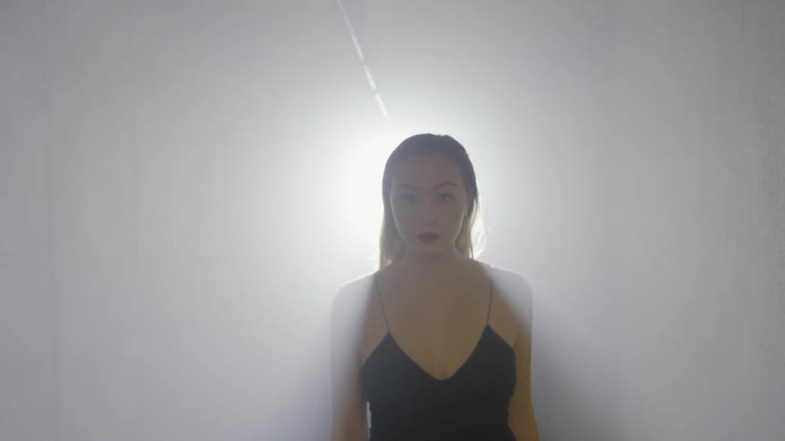Light shines on a woman walking through a hallway