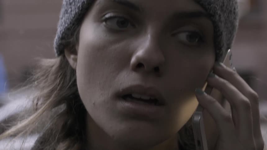 A woman in a beanie talks on her phone
