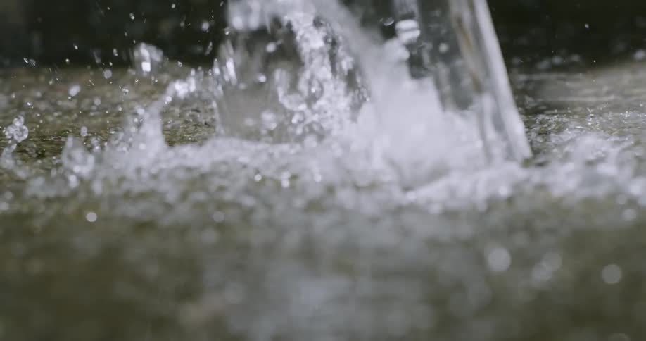 The water pours onto the ground splashing everywhere