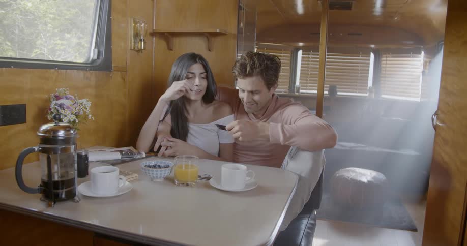 Woman and man sit at a table talking and looking at a photo