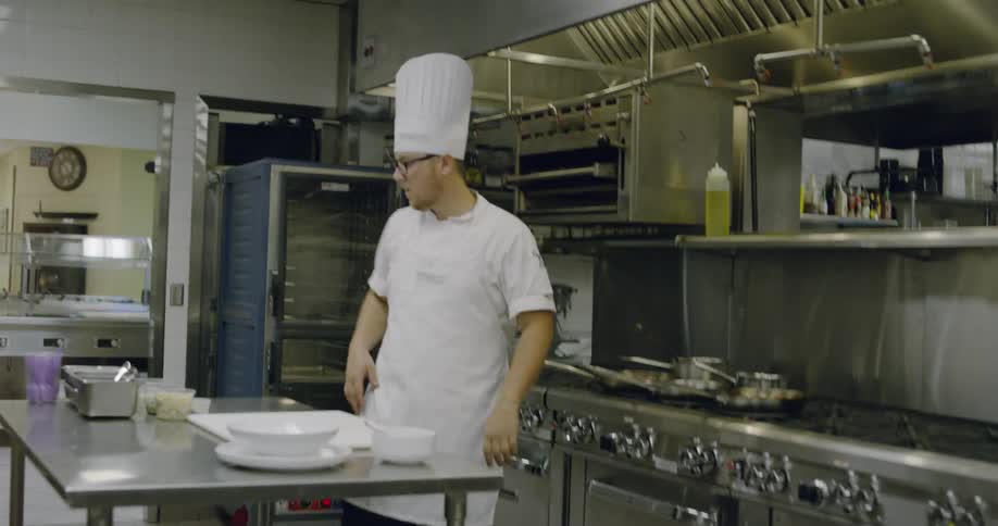 A chef with a white hat is working in the kitchen