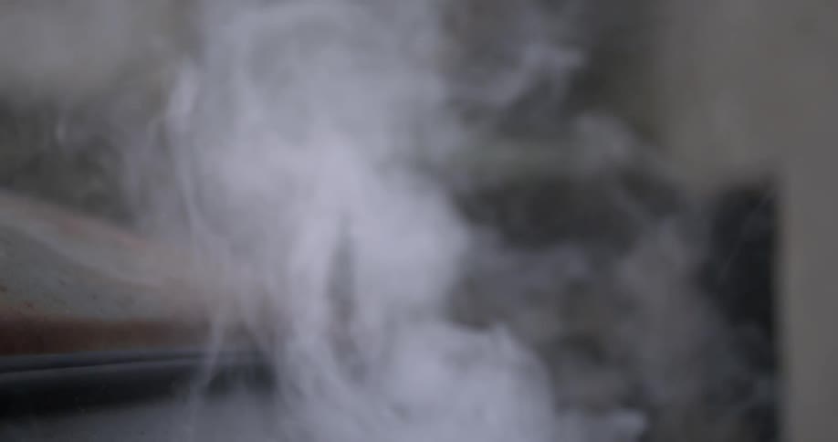 Smoke billows around an old car