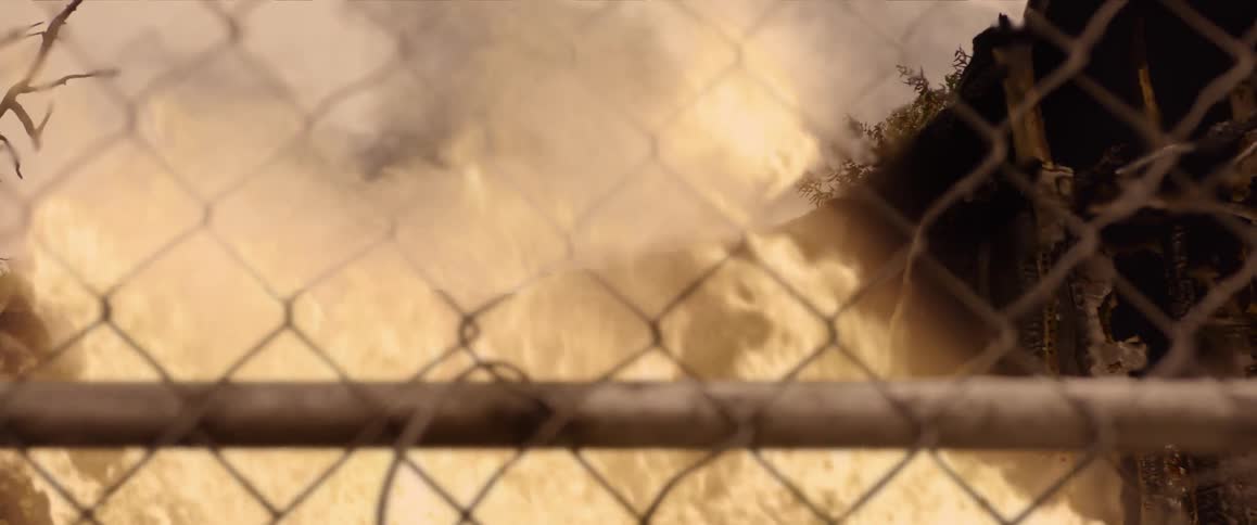 A fire is raging behind this fence