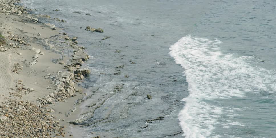 Water splashes to a rocky shore