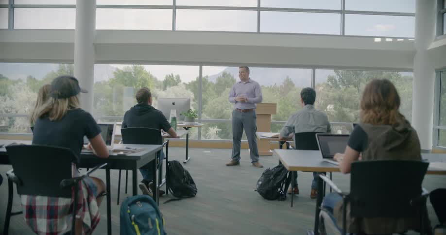 Students in an adult class raise their hands in response to a teacher