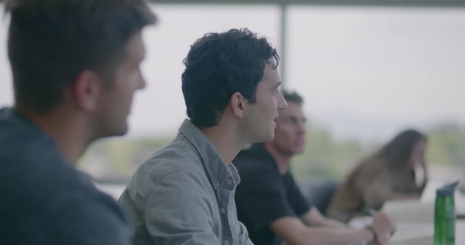 A group of people are sitting around a conference table having a meeting