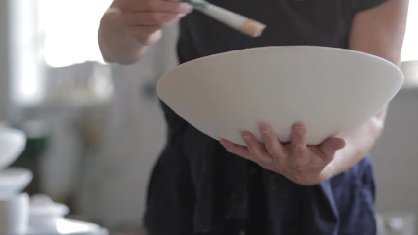 Woman painting the sides of a bowl